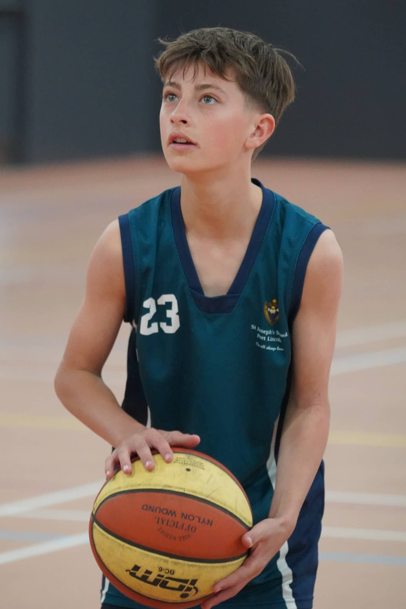 Student about to shoot a basketball into the hoop at a basketball carnival